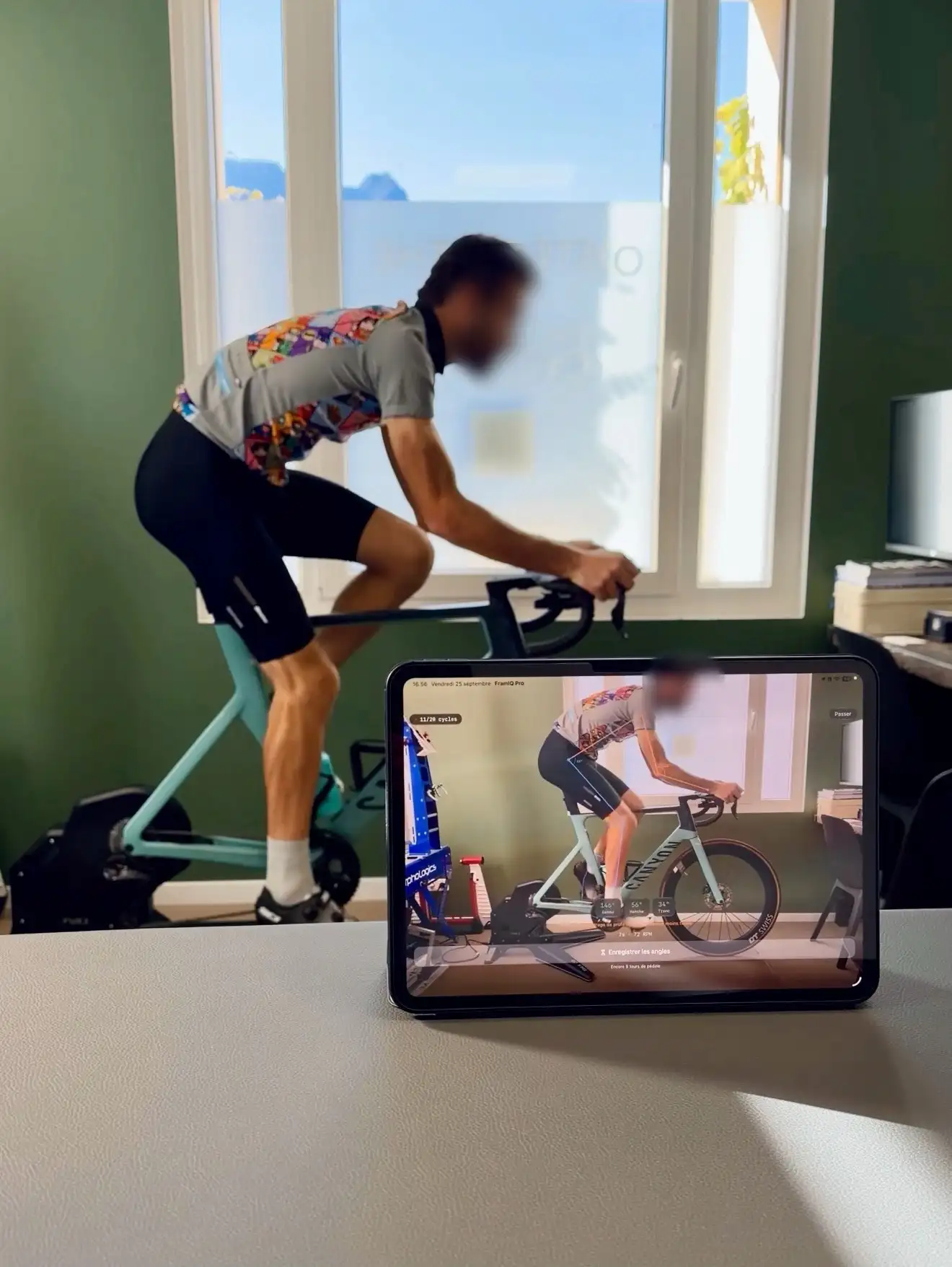 Cyclist on an indoor trainer with FramIQ position analysis on a tablet